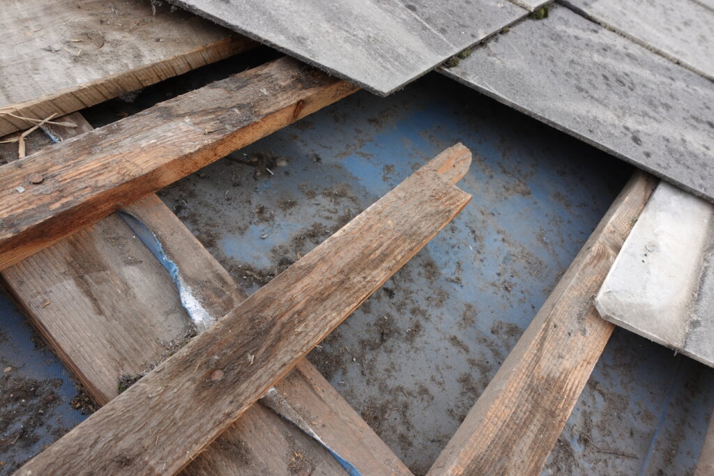 Alte Holzbretter und graue Betonplatten auf verschmutzter blauer Metalloberfläche